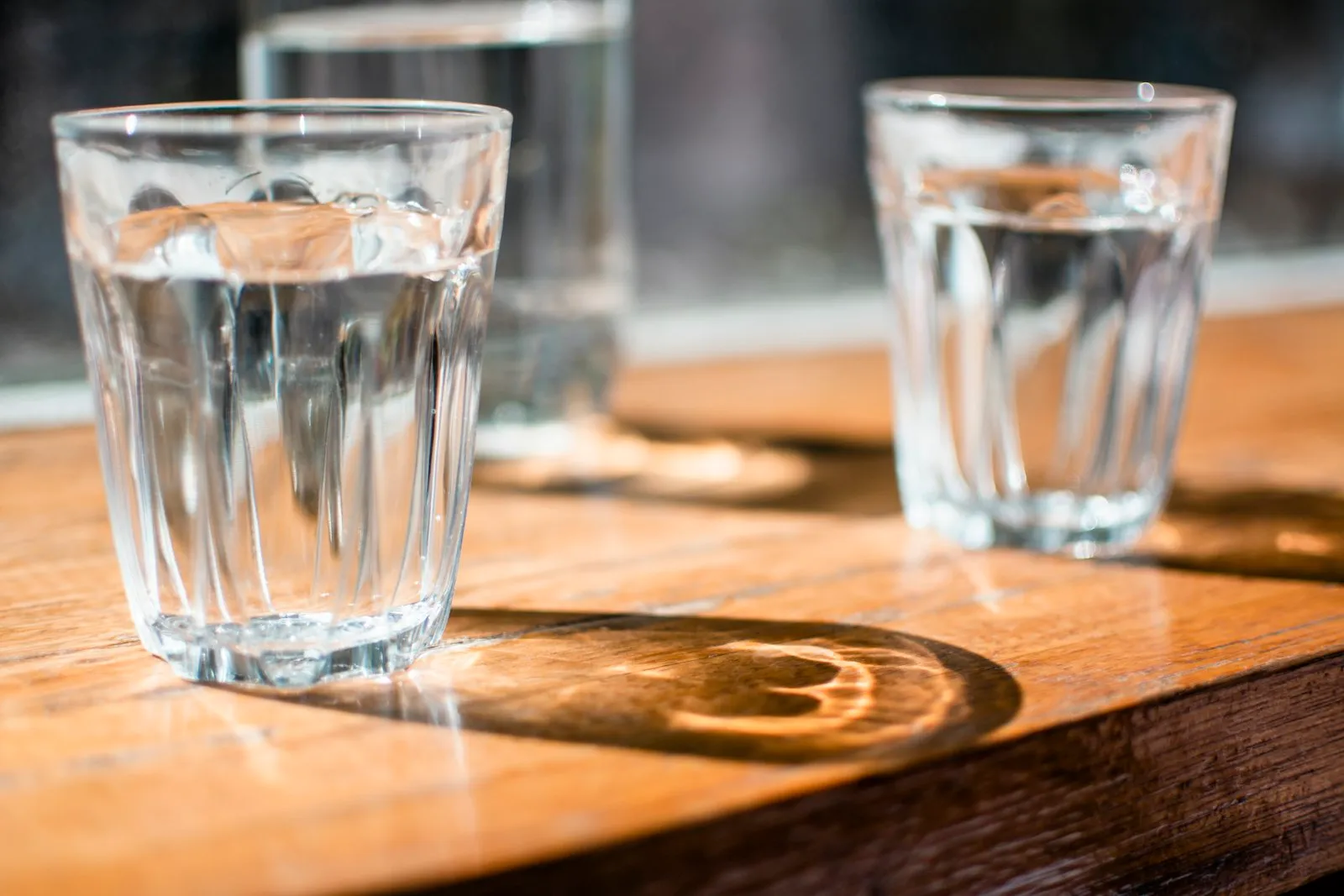 clear glass of water on wooden table, natural light